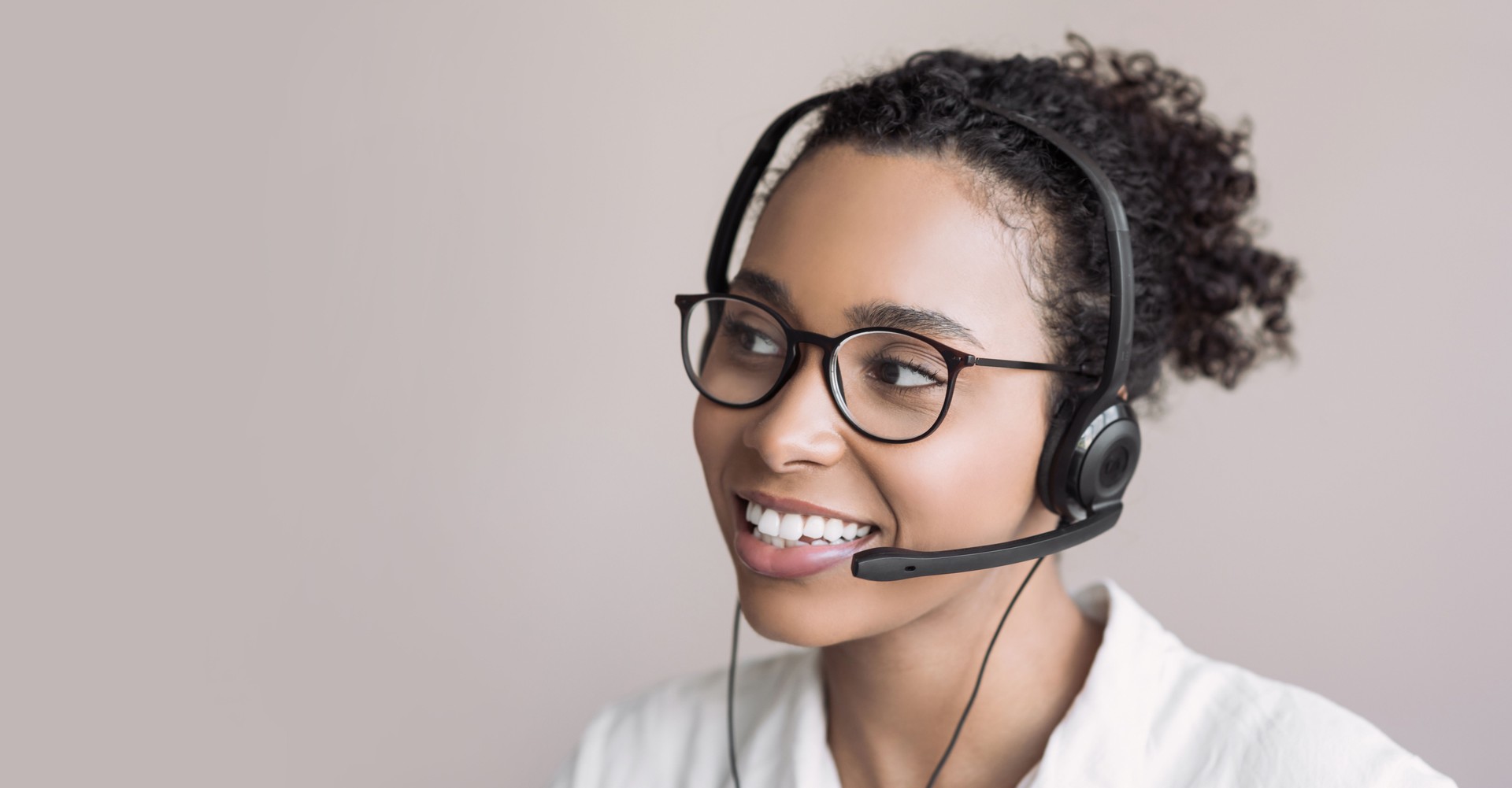 Young woman wearing headset. Portrait of customer service assistant talking on phone